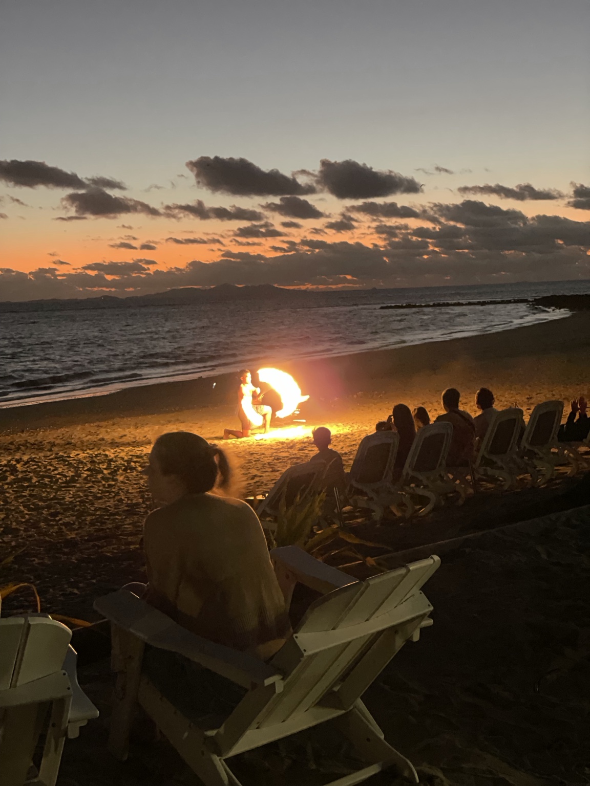 Fire dancer performing on a beach in Fiji at sunset